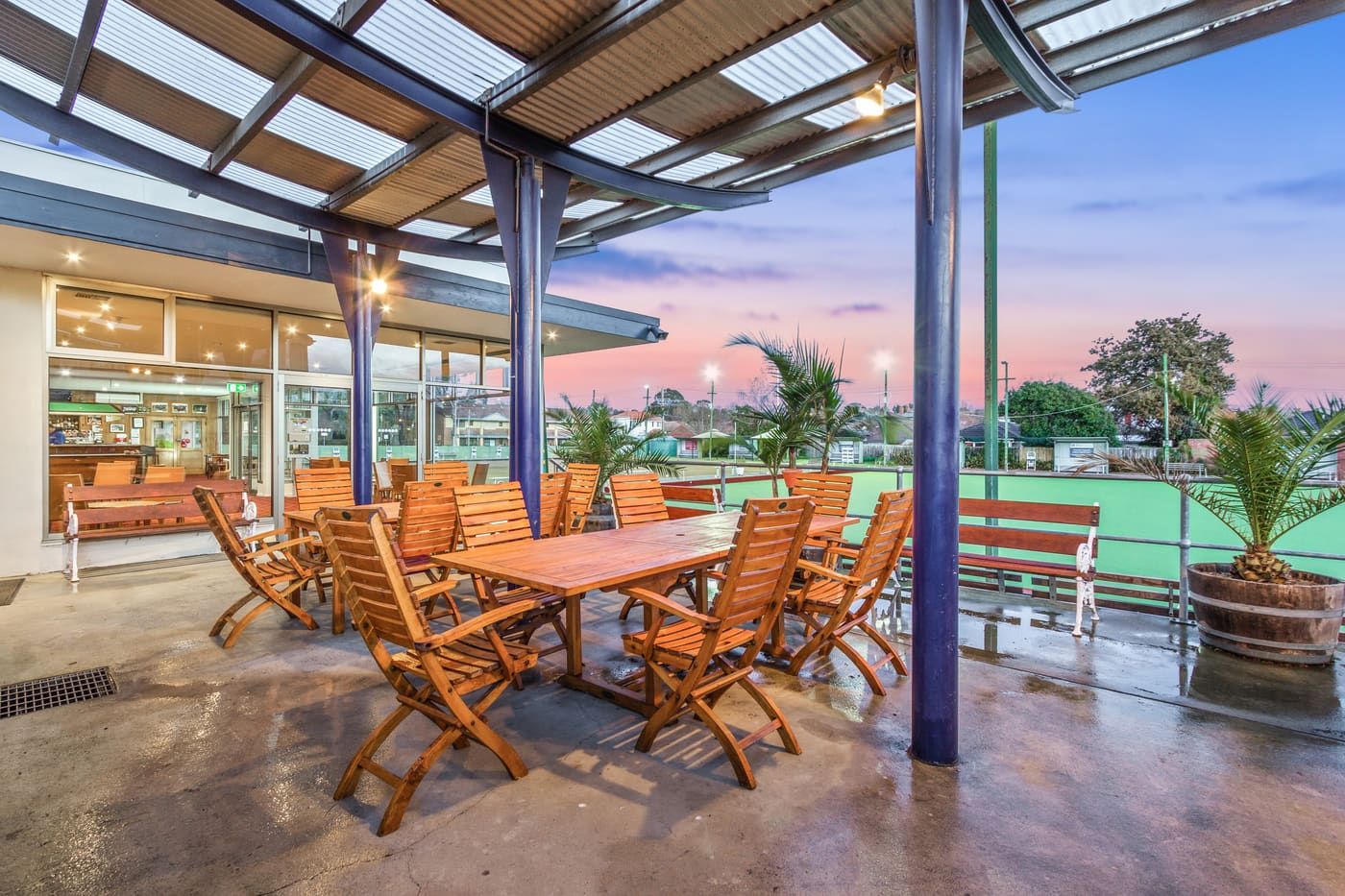 The covered outdoor BBQ deck beside the green at dusk