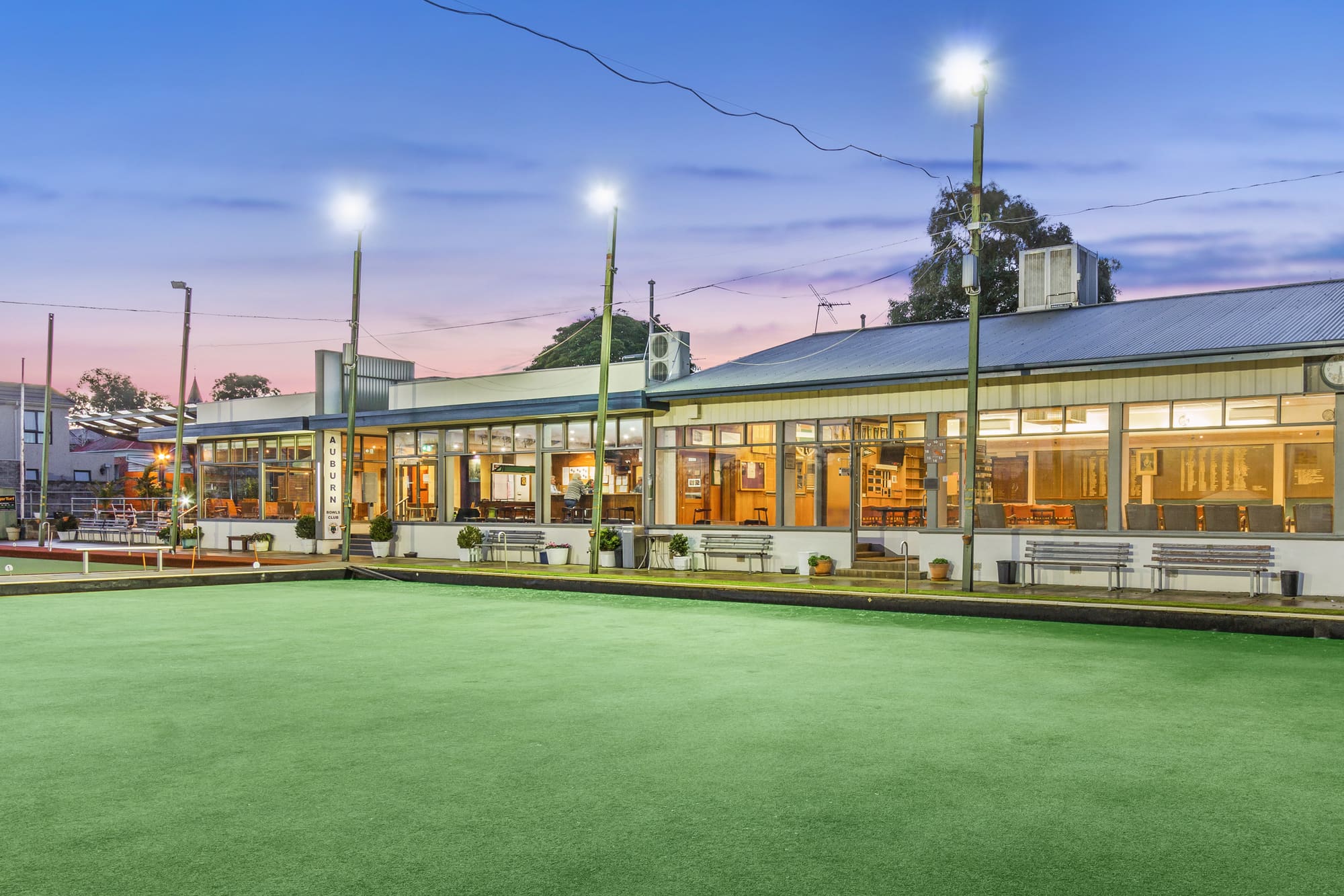 Auburn Bowls Club clubhouse and green at dusk